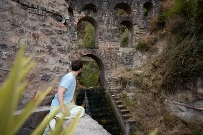 a man sitting on the edge of a stone bridge at Supertramp Hostel Cusco in Cusco