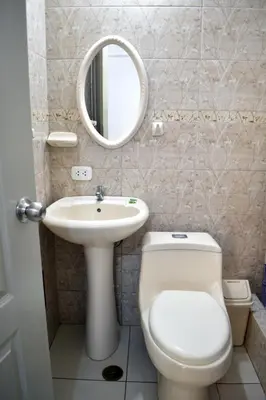 a bathroom with a toilet and a sink and a mirror at Hospedaje El Buen Samaritano in Paracas