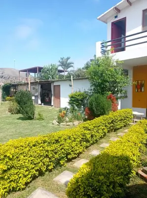 a garden in front of a house with yellow flowers at Bujama Campo Mar in Bujama Baja