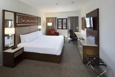 a hotel room with a large bed and a television at Hilton Garden Inn Cusco in Cusco