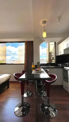 a kitchen and living room with a table and chairs at Allincay Cusco Apart Hotel in Cusco