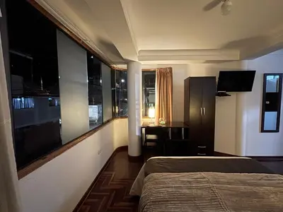 a hotel room with a bed and a large window at Allincay Cusco Apart Hotel in Cusco