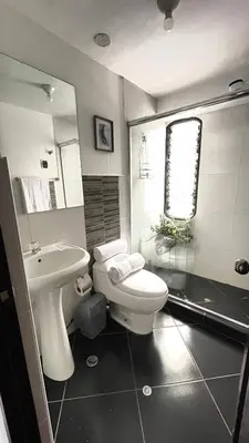 a bathroom with a white toilet and a sink at Allincay Cusco Apart Hotel in Cusco