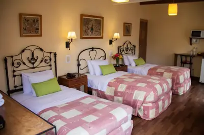a hotel room with two beds with green pillows at El Patio Miraflores in Lima