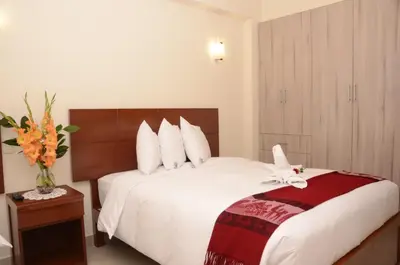a hotel room with a bed with a flower on it at Aqua Hotel Cusco in Cusco