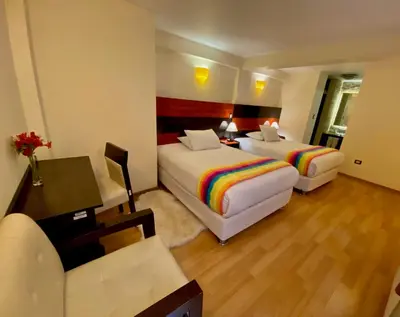 a hotel room with two beds and a desk and a couch at Mistico San Blas Boutique in Cusco