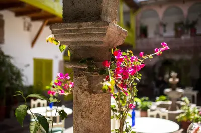 a pole with flowers on it with tables and chairs at Niños Hotel Meloc in Cusco