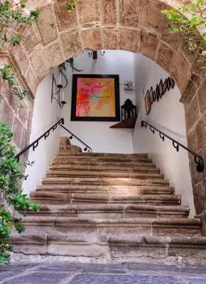 a staircase in a house with a stone archway at Niños Hotel Meloc in Cusco