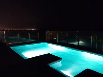 a swimming pool at night with the city lights at Ocean View Beautiful Aparment in Lima