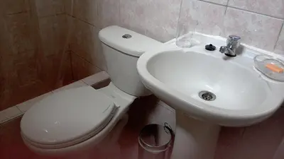 a bathroom with a white toilet and a sink at Hospedaje de Lidia in Lima