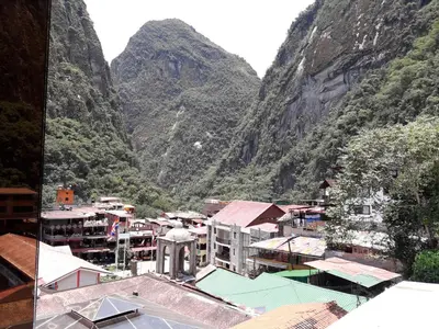 a view of a town with mountains in the background at Hostal Vista Waynapata 123 in Machu Picchu