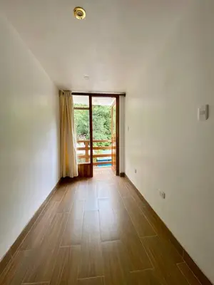a room with a wooden floor and a large window at Mistico Machupicchu Eco B&B in Machu Picchu