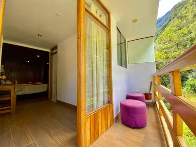 a room with a window and a purple stool at Mistico Machupicchu Eco B&B in Machu Picchu