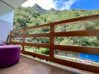 a room with a large window with a mountain view at Mistico Machupicchu Eco B&B in Machu Picchu