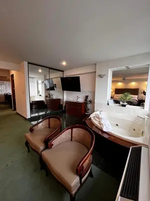 a living room with a bath tub and two chairs at Hotel Boulevard in Lima