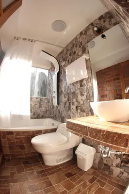 a bathroom with a toilet and a tub and a sink at Parwa Guest House in Ollantaytambo
