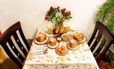 a table with a breakfast of eggs and oranges on it at Parwa Guest House in Ollantaytambo