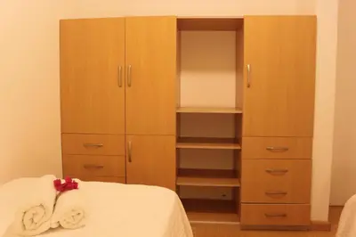 a bedroom with a closet and a bed with towels at Caihuayna Apart Hotel in Paracas