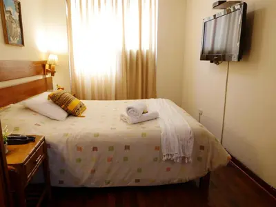 a bedroom with a bed with two towels on it at Suite Service Apart Hotel in Lima
