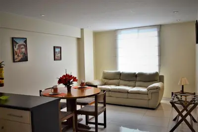 a living room with a couch and a table at Suite Service Apart Hotel in Lima