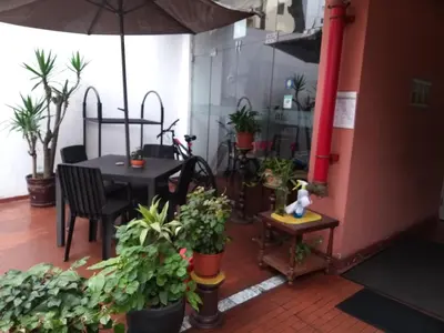 a patio with a table and potted plants and an umbrella at Suite Service Apart Hotel in Lima
