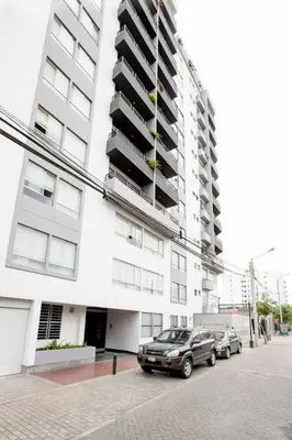 two cars parked in front of a large building at MLA apartments - Kennedy in Lima