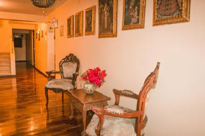 a room with two chairs and a table with flowers on it at Hotel Manhattan Inn Airport in Lima