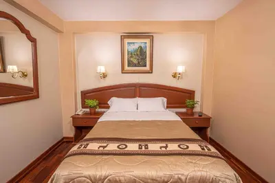 a bedroom with a large bed with two night stands at Hotel Manhattan Inn Airport in Lima