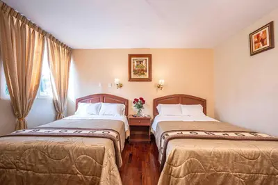 a hotel room with two beds and a window at Hotel Manhattan Inn Airport in Lima