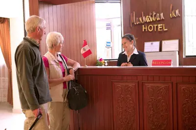 a group of people standing at a reception desk at Hotel Manhattan Inn Airport in Lima