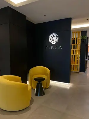 a lobby with two yellow chairs and a sign at Hotel Ferré Miraflores in Lima