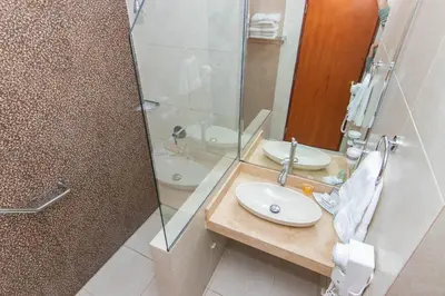 a bathroom with two sinks and a glass shower at Miraflores Colon Hotel in Lima