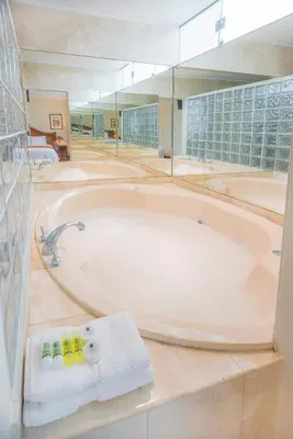 a large bathroom with a bath tub with towels at Miraflores Colon Hotel in Lima