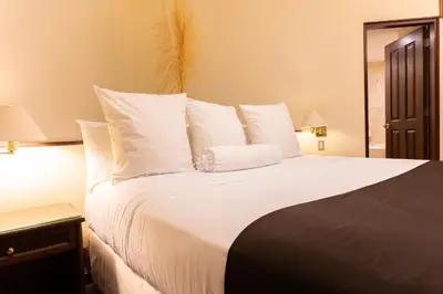 a bedroom with a large bed with white sheets and pillows at J&A Classic Hotel in Lima