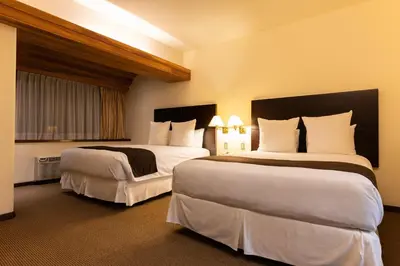 a hotel room with two beds with white pillows at J&A Classic Hotel in Lima