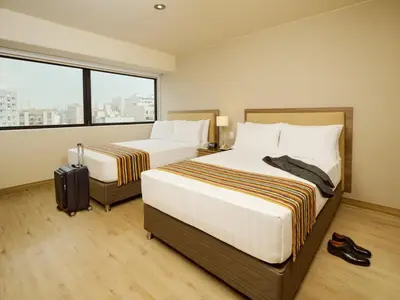 a hotel room with two beds and a window at Estelar Apartamentos Bellavista in Lima