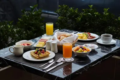 a table topped with plates of breakfast foods and drinks at Estelar Apartamentos Bellavista in Lima
