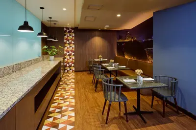 a restaurant with tables and chairs and a counter at Estelar Apartamentos Bellavista in Lima