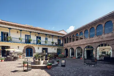 a large building with a courtyard with potted plants at Palacio del Inka, a Luxury Collection Hotel, Cusco in Cusco