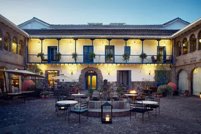 a courtyard with tables and chairs in front of a building at Palacio del Inka, a Luxury Collection Hotel, Cusco in Cusco