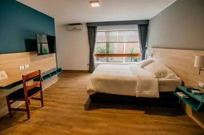 a bedroom with a bed and a desk and a window at Daniel's Apart Hotel in Lima