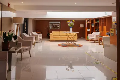 a lobby with a couch and a table and chairs at Daniel's Apart Hotel in Lima