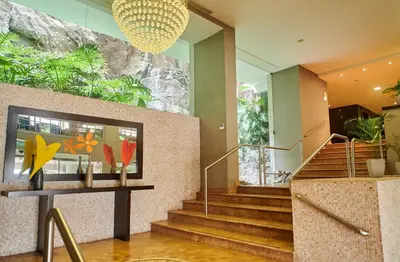 a lobby with stairs and a large window with plants at Casa Andina Premium Golf Los Incas in Lima