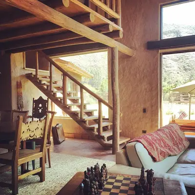 a living room with a staircase and a chess board at Luxury House & Unique Experience at Sacred Valley, Urubamba, Cusco in Urubamba