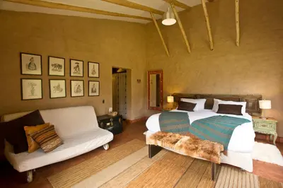 a bedroom with a large bed and a couch at Luxury House & Unique Experience at Sacred Valley, Urubamba, Cusco in Urubamba