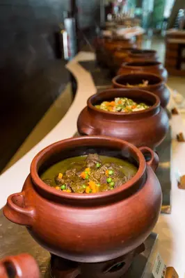 a row of clay pots filled with soup on a counter at Delfines Hotel & Convention Center in Lima