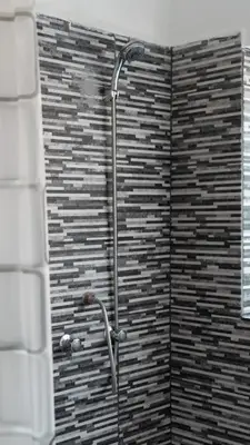 a shower in a bathroom with a brick wall at House in Cusco in Cusco