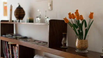a vase with orange flowers sitting on a shelf at House in Cusco in Cusco
