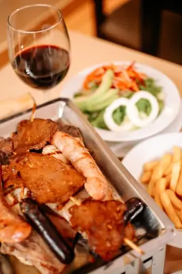 a table with a plate of food and a glass of wine at Hotel Carrera in Lima