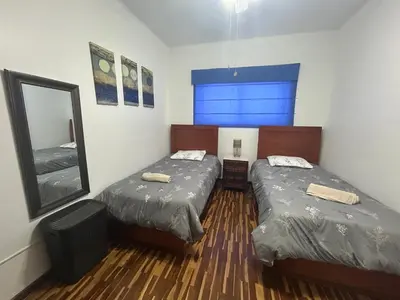 a room with two beds and a mirror in it at Departamento en San Isidro in Lima